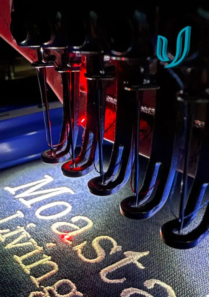 Multi-needle embroidery machine with thread spools on fabric for cost effective branding