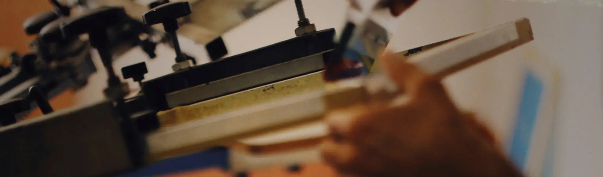 Silk screen printing press with squeegee for large volume printing on long lasting fabric