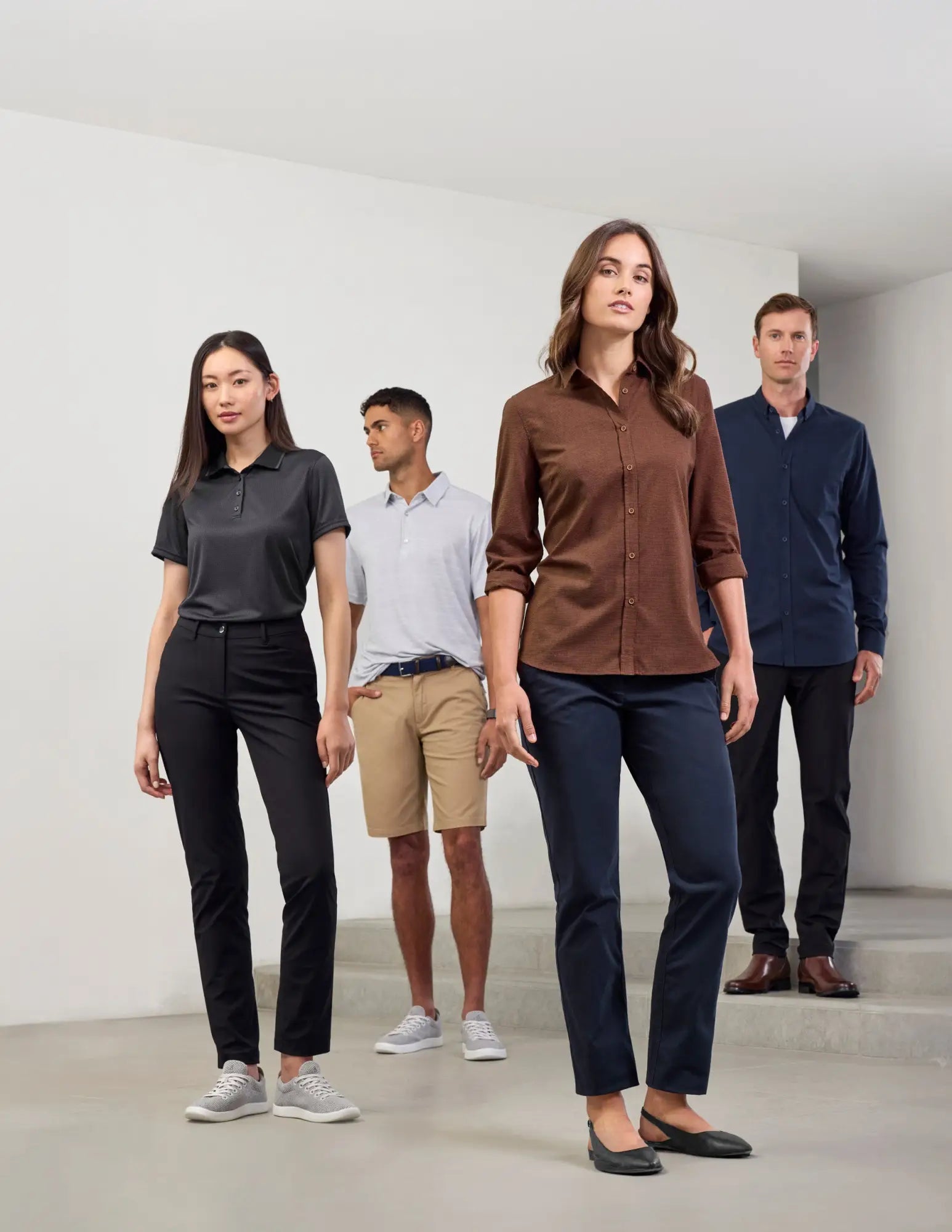 Four people modeling casual and business outfits at Uniform Super Store for easy uniform management