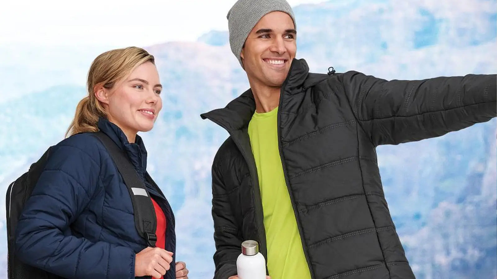 Couple in vests with bicycles showcasing Winning Spirit’s extensive workwear collection