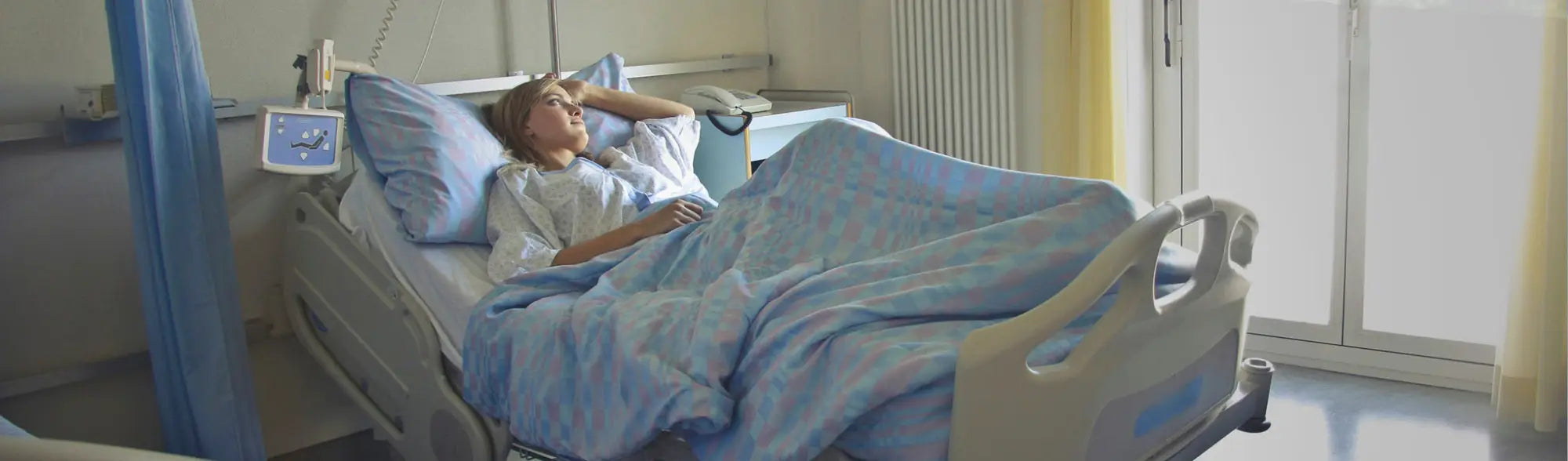 Hospital bed with patient in comfortable patient gowns from the Patient Gowns collection