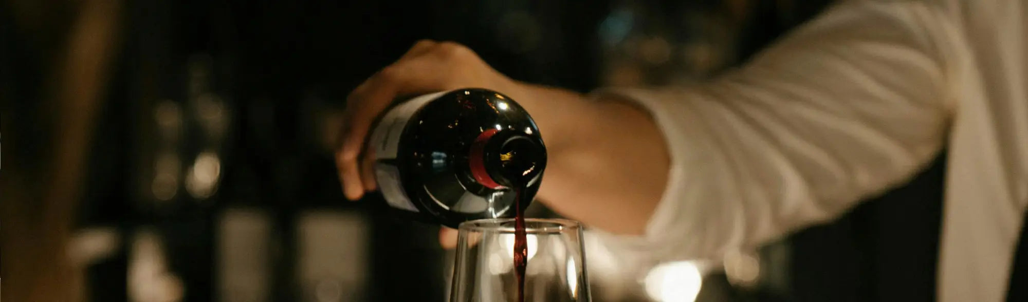 Red wine being poured in hospitality uniforms, perfect for workwear in chill settings
