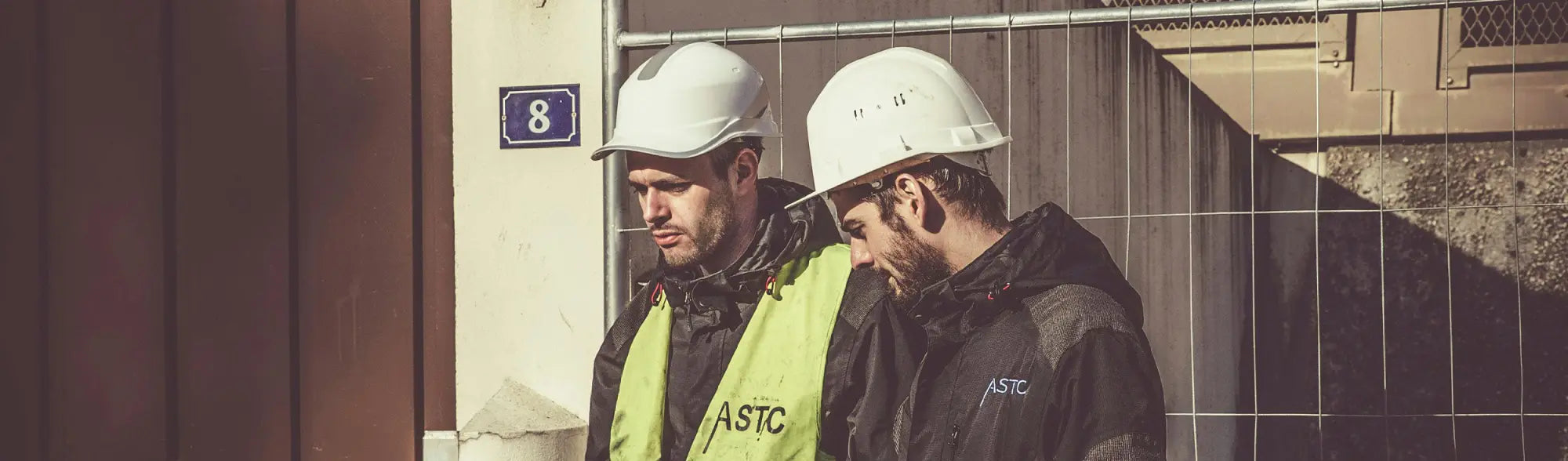 Two construction workers in hard hats showing essential safety equipment for maximum visibility