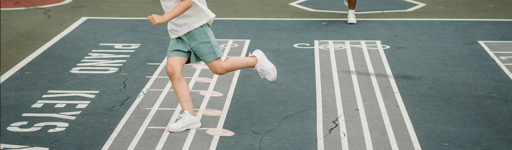 Child running on painted piano keys in School Shorts collection, perfect for school uniforms
