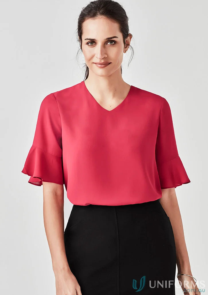 Woman in Aria Fluted Blouse with fluted sleeves, perfect functional workwear option
