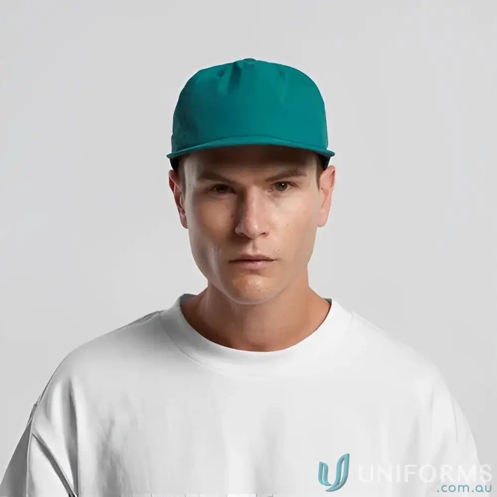 Man wearing teal AS Colour 1114 Surf Cap made of recycled nylon and plastic snapback