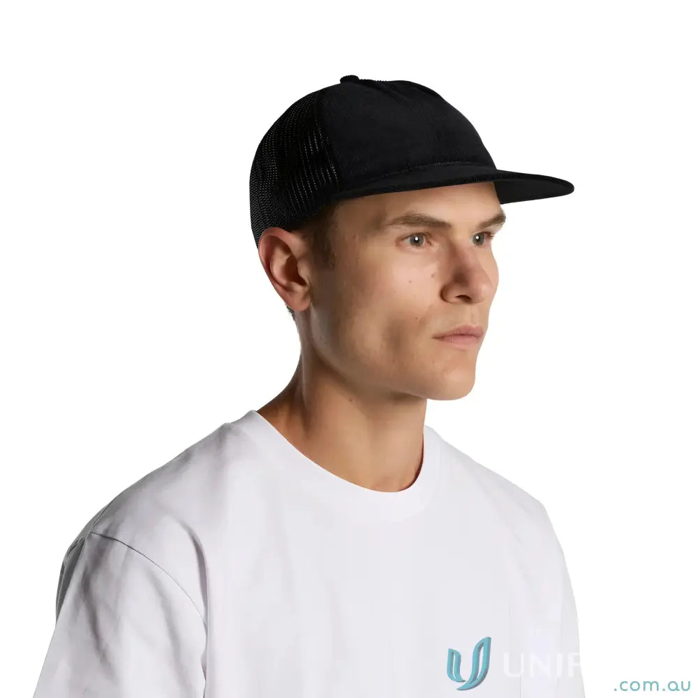Man wearing black trucker hat with flat peak made from cotton 16-wale partridge cord