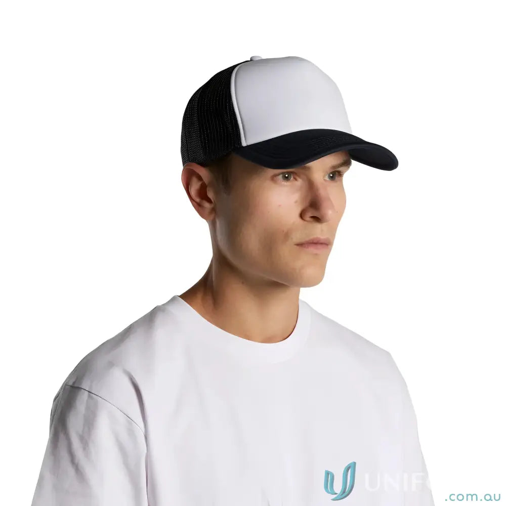 Man wearing black and white trucker hat with curved peak and recycled polyester mesh