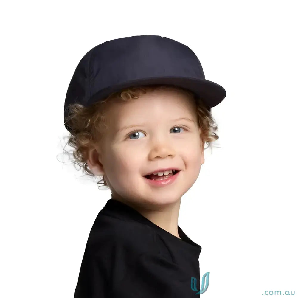 Smiling toddler in navy blue cap with foam peak, made from recycled nylon