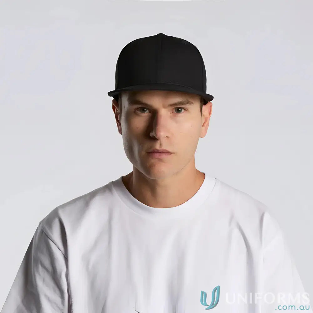 Man wearing black flat peak Colour Stock Flex Cap 1106 in white t-shirt