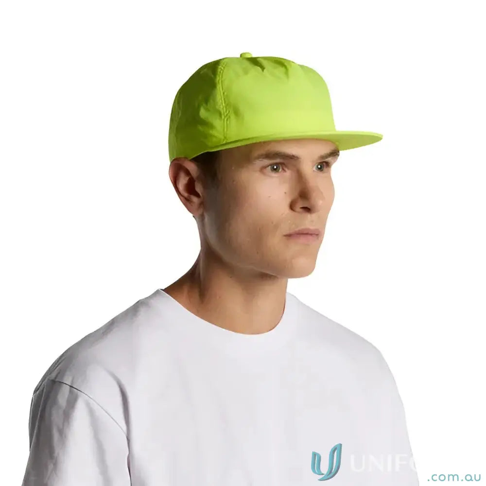 Man wearing neon green surf safety cap made of recycled nylon and white t-shirt