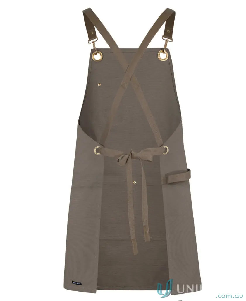 Brown eyelet canvas apron with criss-cross back straps and waist ties for the ultimate canvas apron look