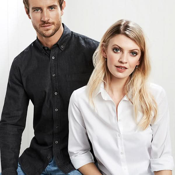 Man and woman sitting side by side against a white background