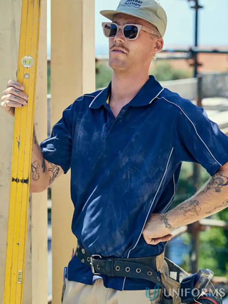 Male construction worker in cool mesh polo with reflective piping holding a yellow level