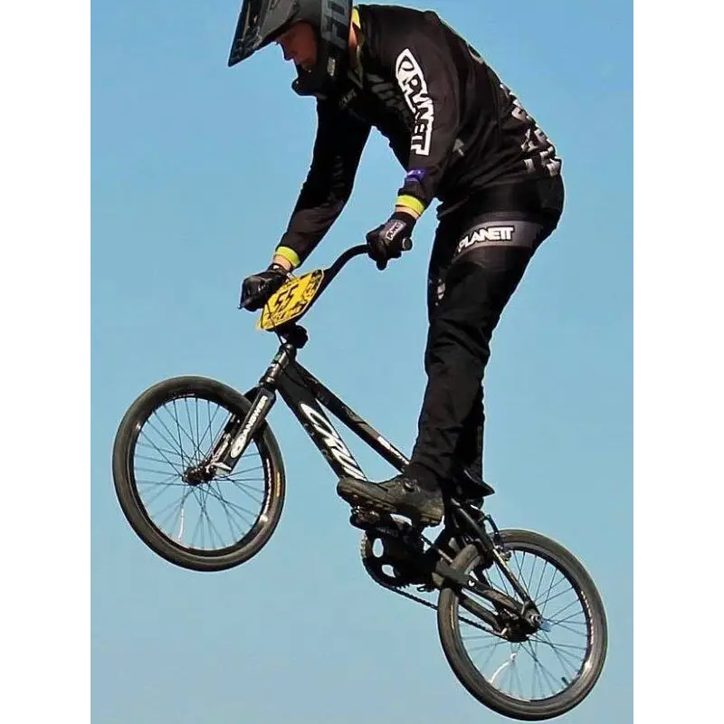Black bmx bike with white branding and yellow race number plate shown with custom av8 ride pant workwear uniform