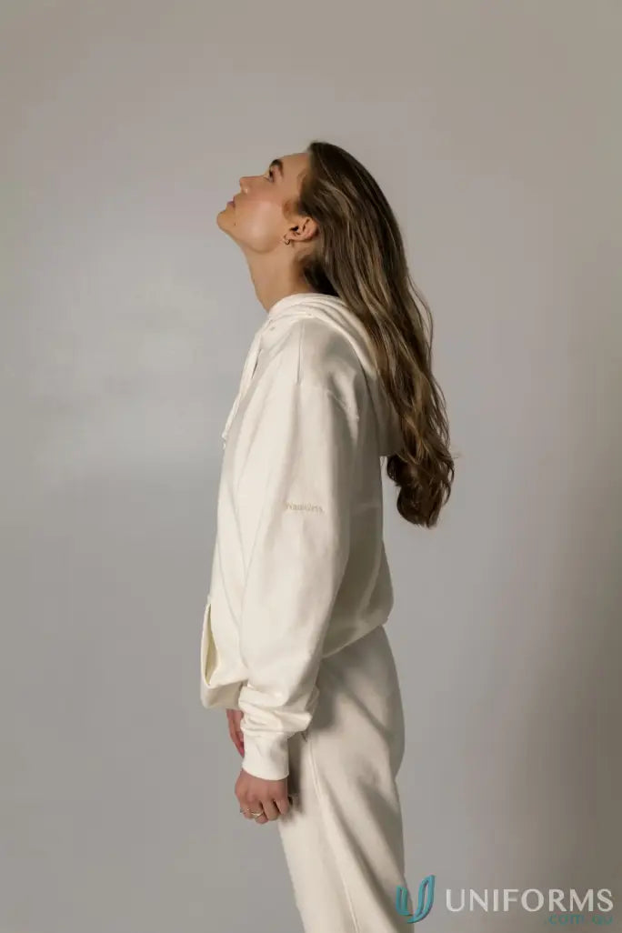 Woman in a cream-colored Hudson Oversized Cotton Hoodie, a stylish garment dyed hoodie perfect for uniforms