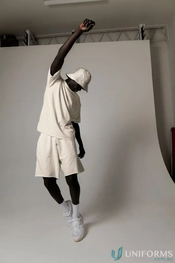 Man in matching beige Tommy Trackshorts jumping, perfect for uniforms or casual workwear