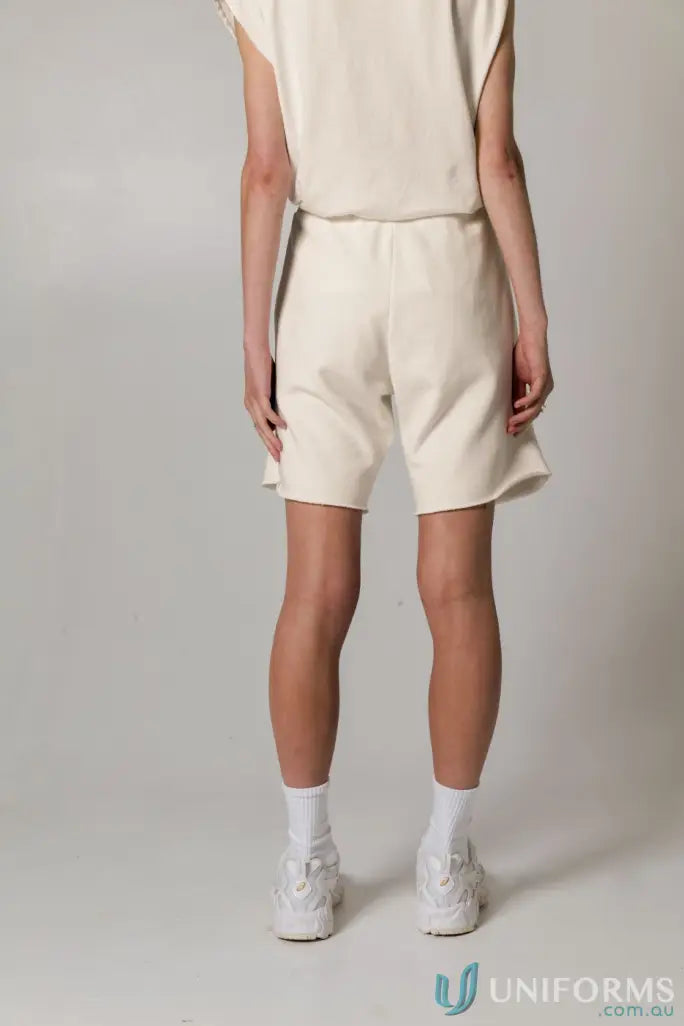 Person wearing cream-colored Tommy Trackshort PFD, perfect for uniforms and workwear