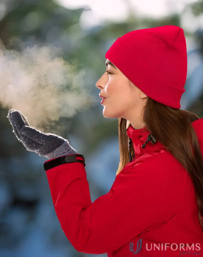 Woman in red Eco Roll RPET Knit Beanie blowing breath into her gloved hand