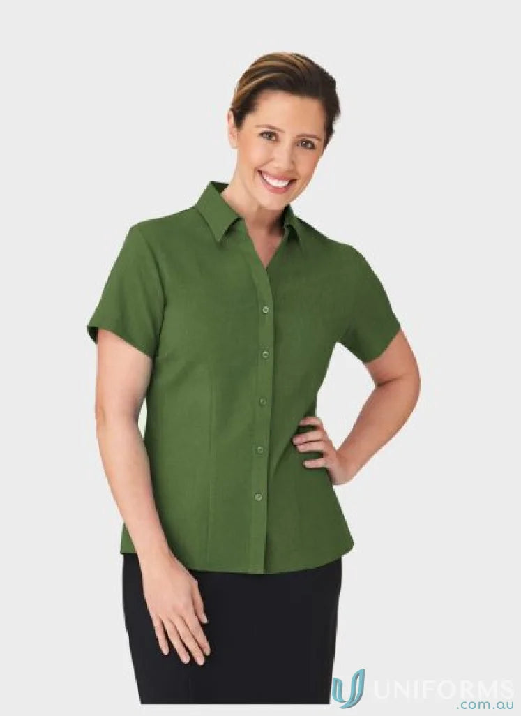 Woman in a green button-down shirt and black skirt wearing Ezylin Ladies S/S Shirt, perfect workwear for uniforms