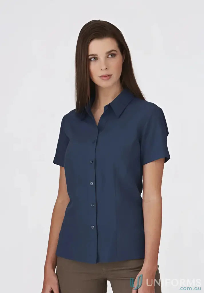 Woman in navy blue Ezylin Ladies S/S Shirt and brown pants, perfect workwear or uniforms