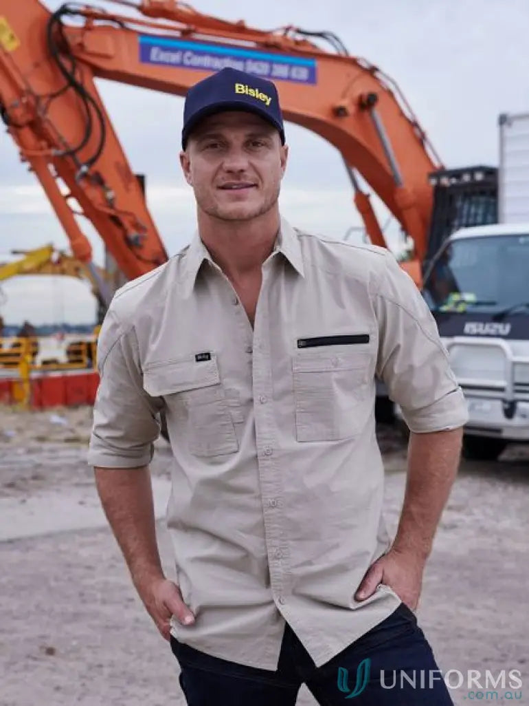 Man wearing tan Flx & Move Utility Work Shirt with active fit and blue cap