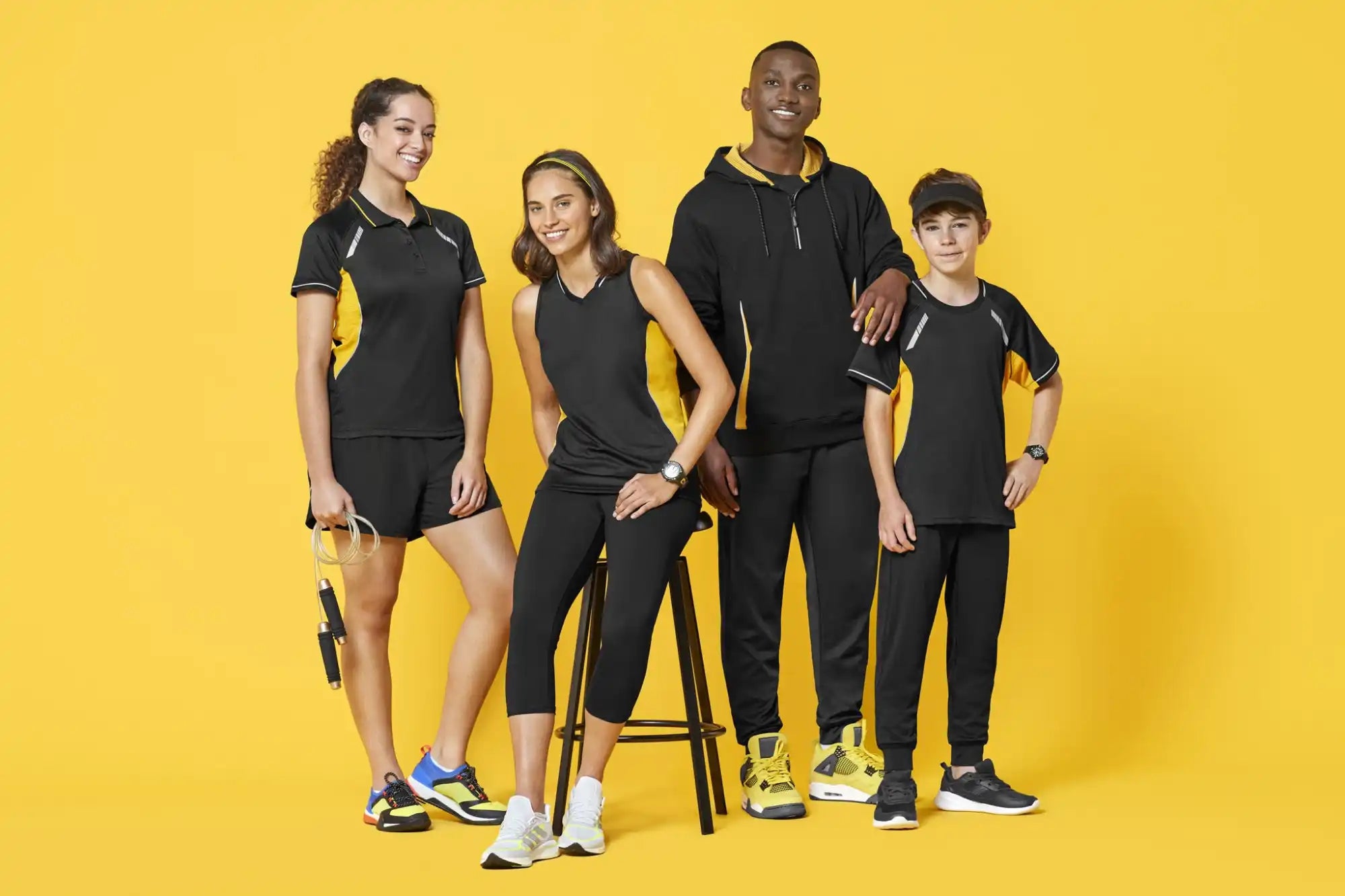 Four people wearing black and yellow athletic clothing.
