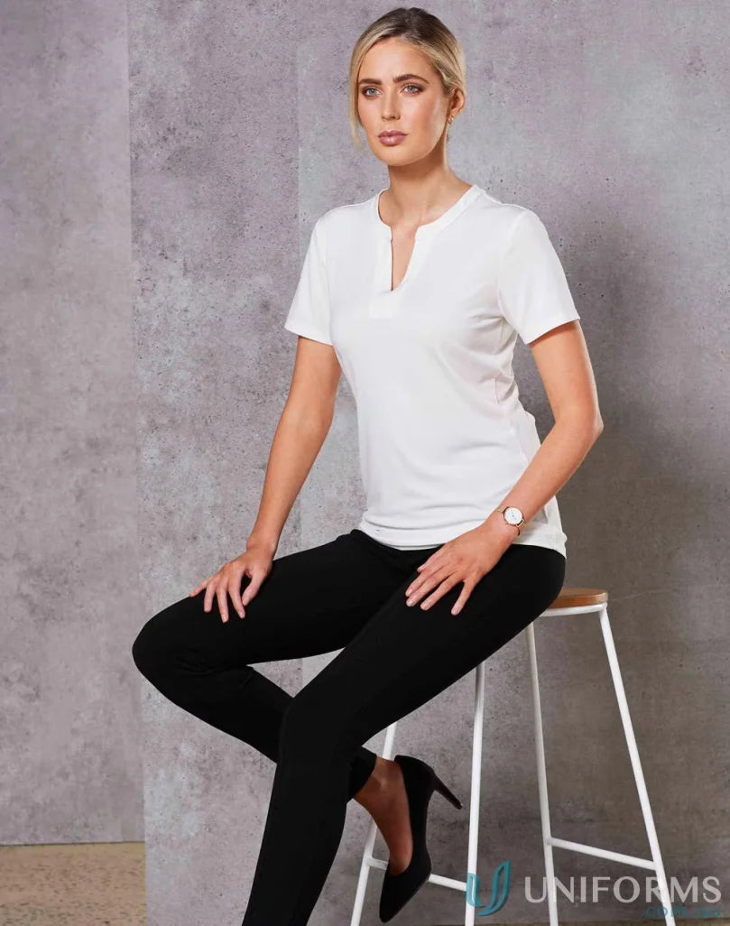Ladies Isabel Stretch Knit Top worn by woman in white short-sleeved v-neck with black skinny pants