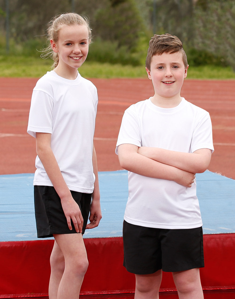 Two kids in ts23k Winning Spirit Kids CoolDry tees with black shorts on track