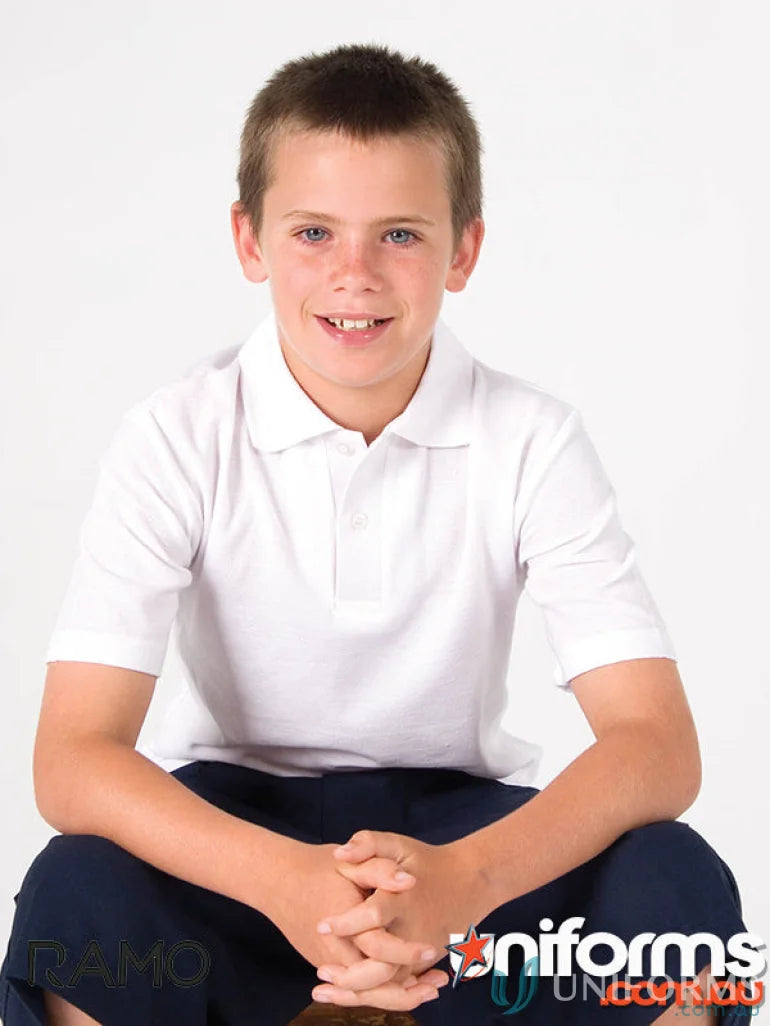 Cute kid in a kids polo uniform wearing a white short-sleeved polo shirt and dark pants