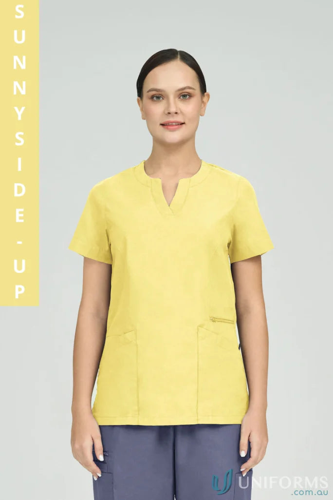 Lady wearing Ladies Amelia Scrub Top with princess seams and zip pocket in yellow
