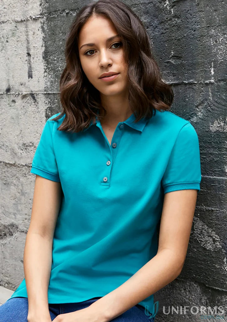Lady wearing a teal Ladies City City Polo short sleeve polo shirt for a casual look