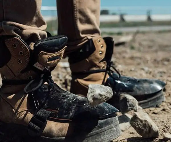 Worn work boots with toe protectors and boot straps for metatarsal guard upgrade