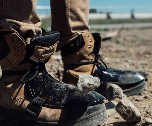 Worn work boots with toe protectors and boot straps for metatarsal guard upgrade