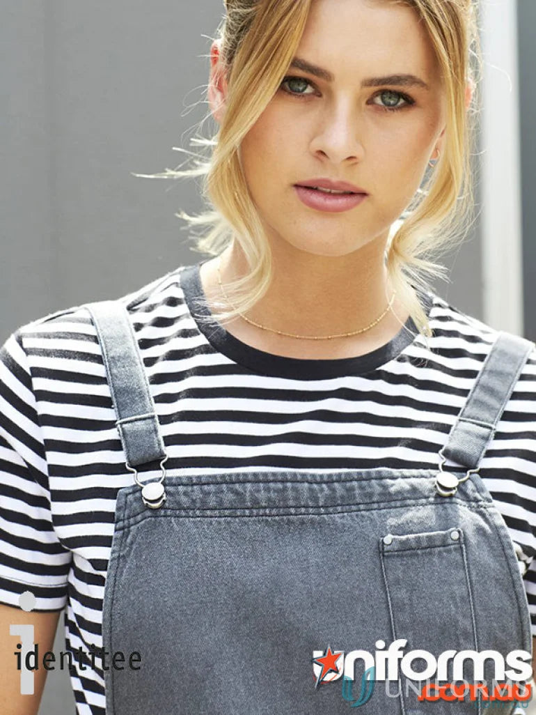 Woman in black and white striped shirt and dark gray stonewash blue dungaree with reinforced metal rivets and metal dungaree clip