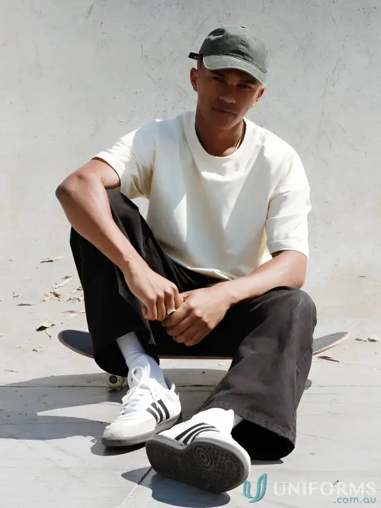 Man sitting on skateboard wearing Luxe Oversized Tee with oversized fit and casual style