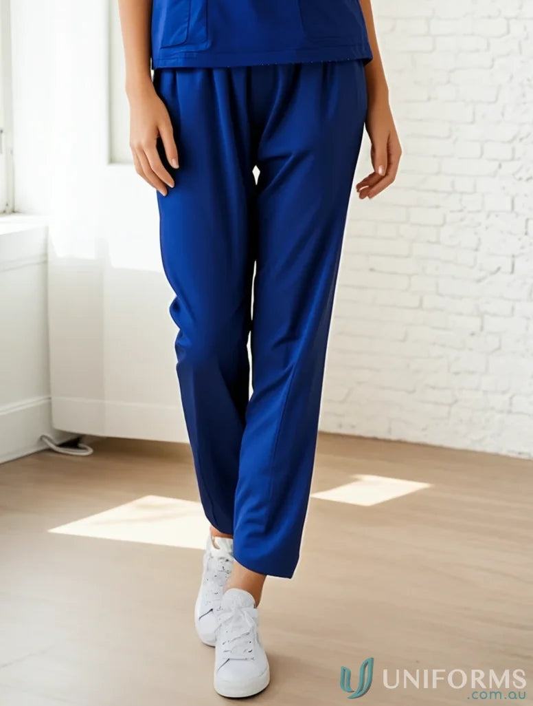 Royal blue medi8 reversible scrub pants with white sneakers showing unisex reversible pants style