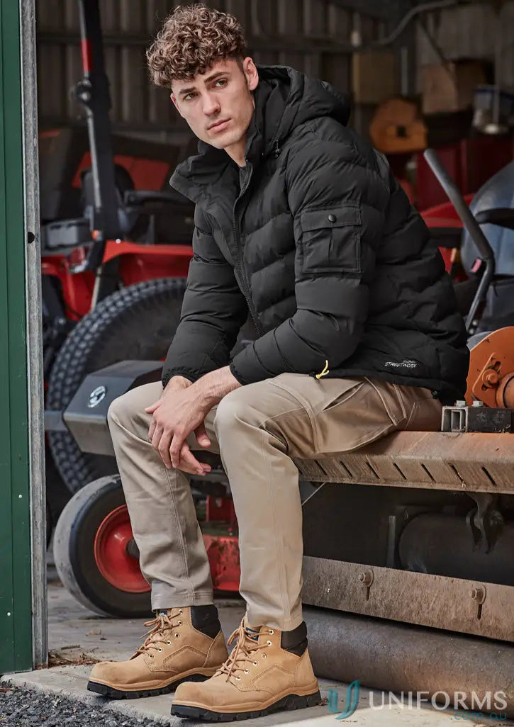 Young man wearing black puffer jacket and tan stretch cargo pants for men’s essential basic style