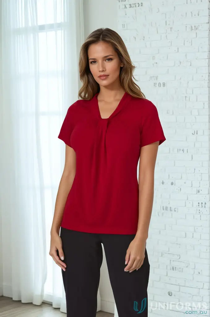 Woman in red top with soft draped neckline and comfortable fit in Pippa Ladies SS Top