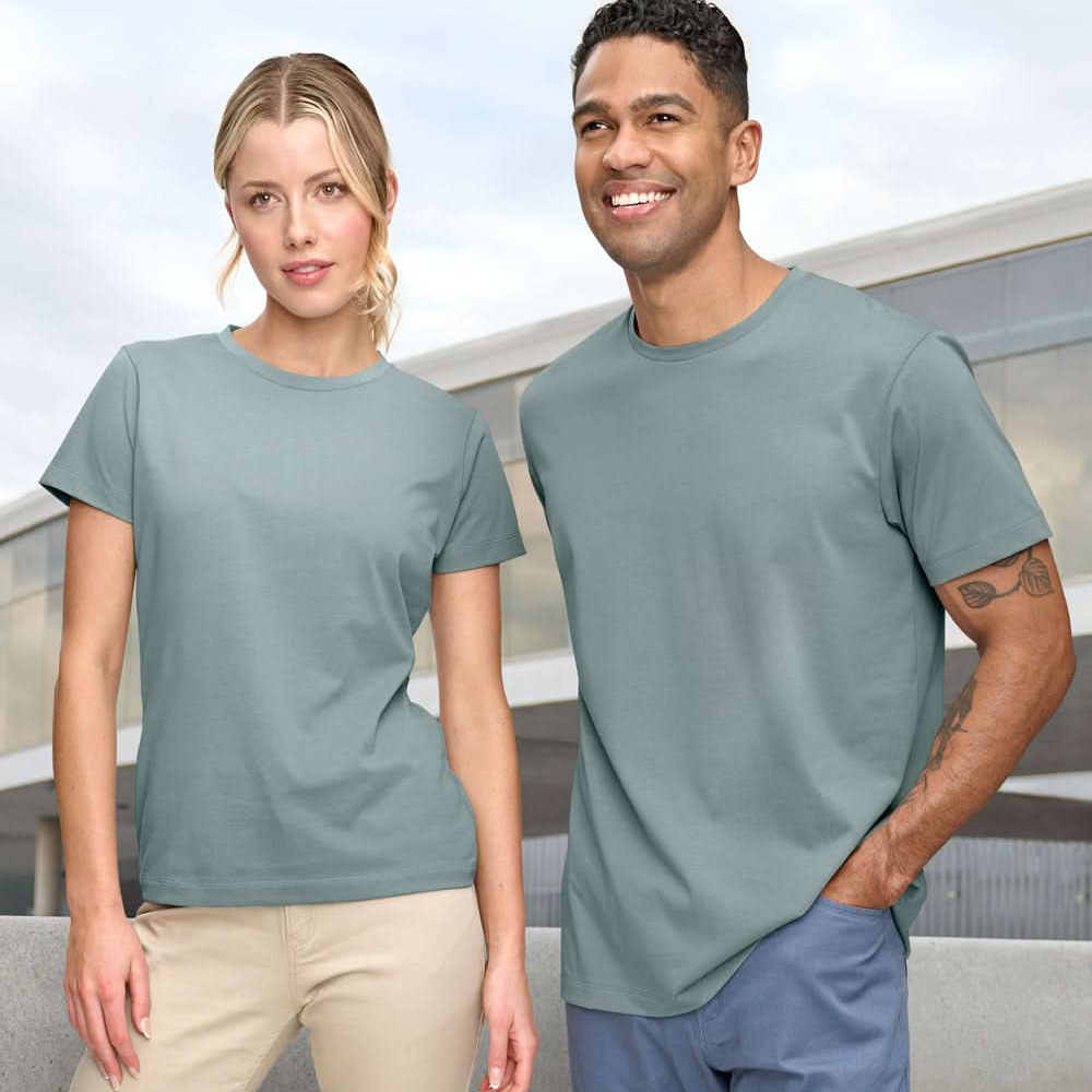 Two people wearing matching light blue t-shirts in an outdoor setting.