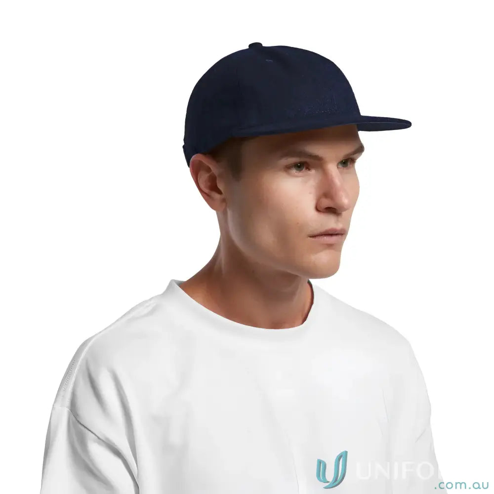 Man in navy blue flat-brimmed cap with adjustable metal clasp and tonal under-peak lining