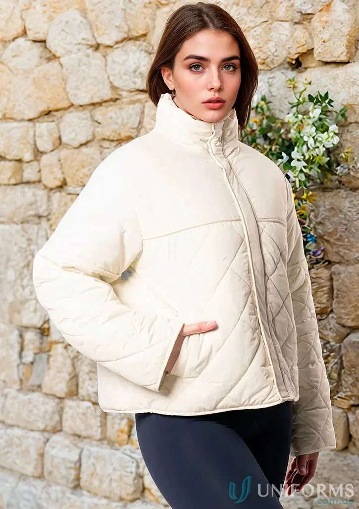 Cream-colored quilted puffer jacket with high collar and zip front perfect for workwear and uniforms