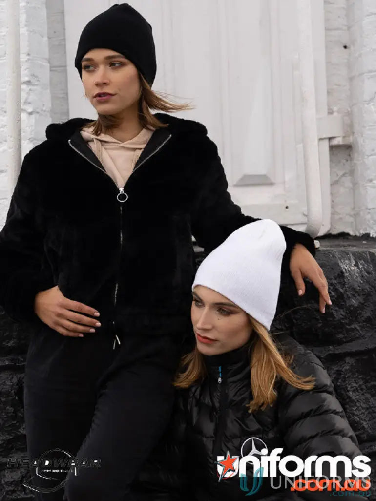 Two women wearing stylish cable knit beanies perfect for uniforms or workwear