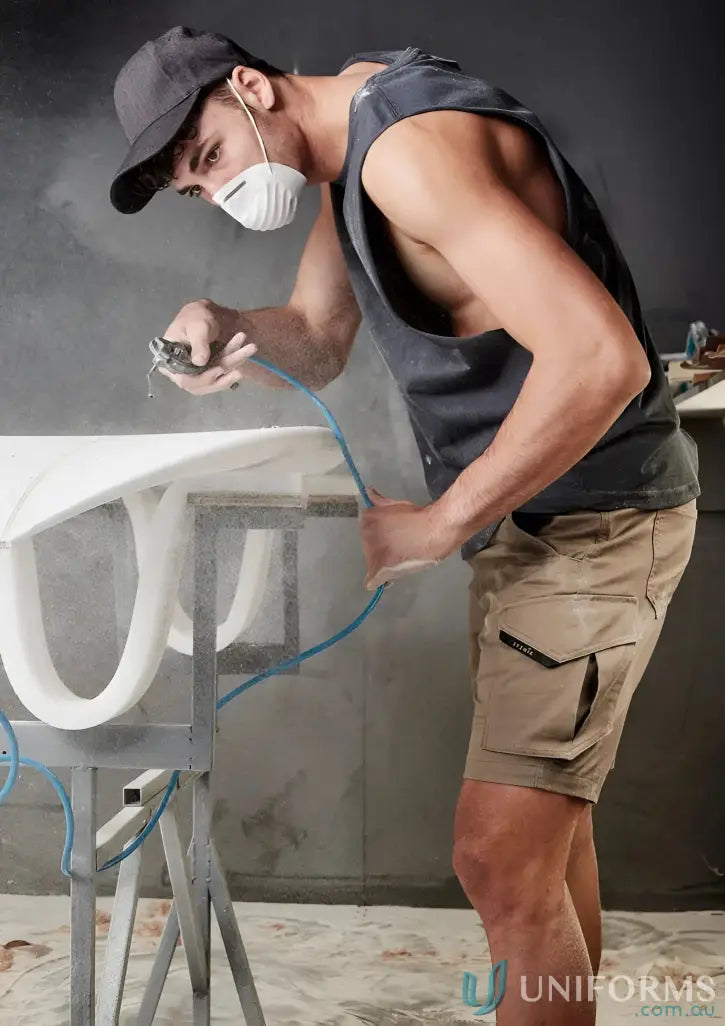 Man spray-painting furniture with Rugged Cooling Stretch Shorts in sun protection gear