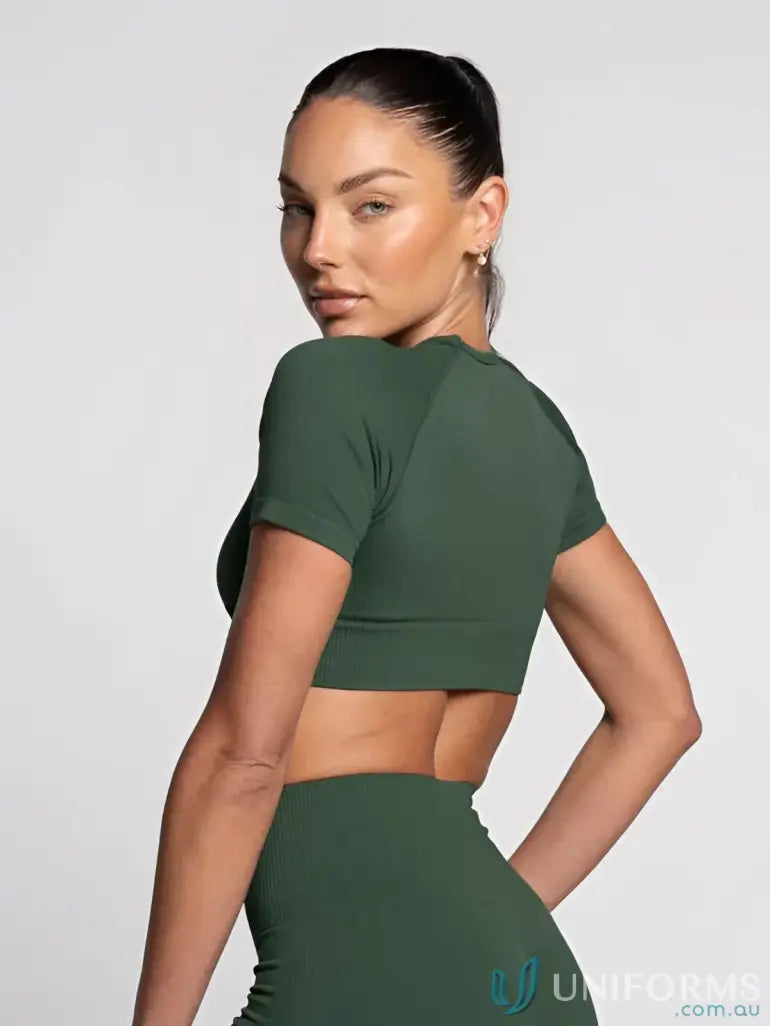 Woman in green seamless crop top with round neck, perfect for uniforms or casual wear