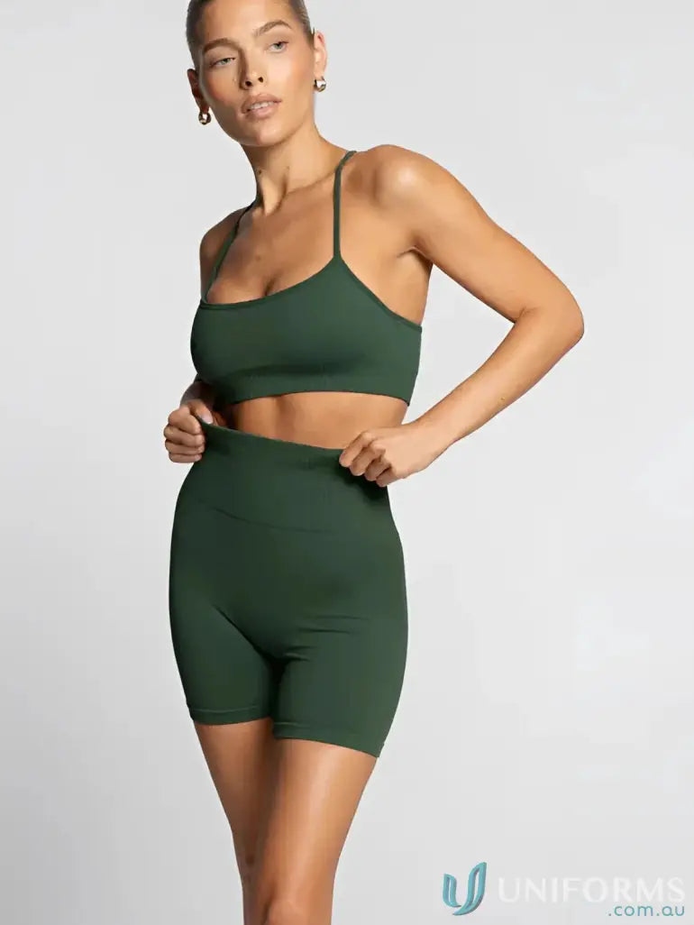 Green seamless athletic set with matching sports bra and biker shorts, likely made of spandex or polyester.