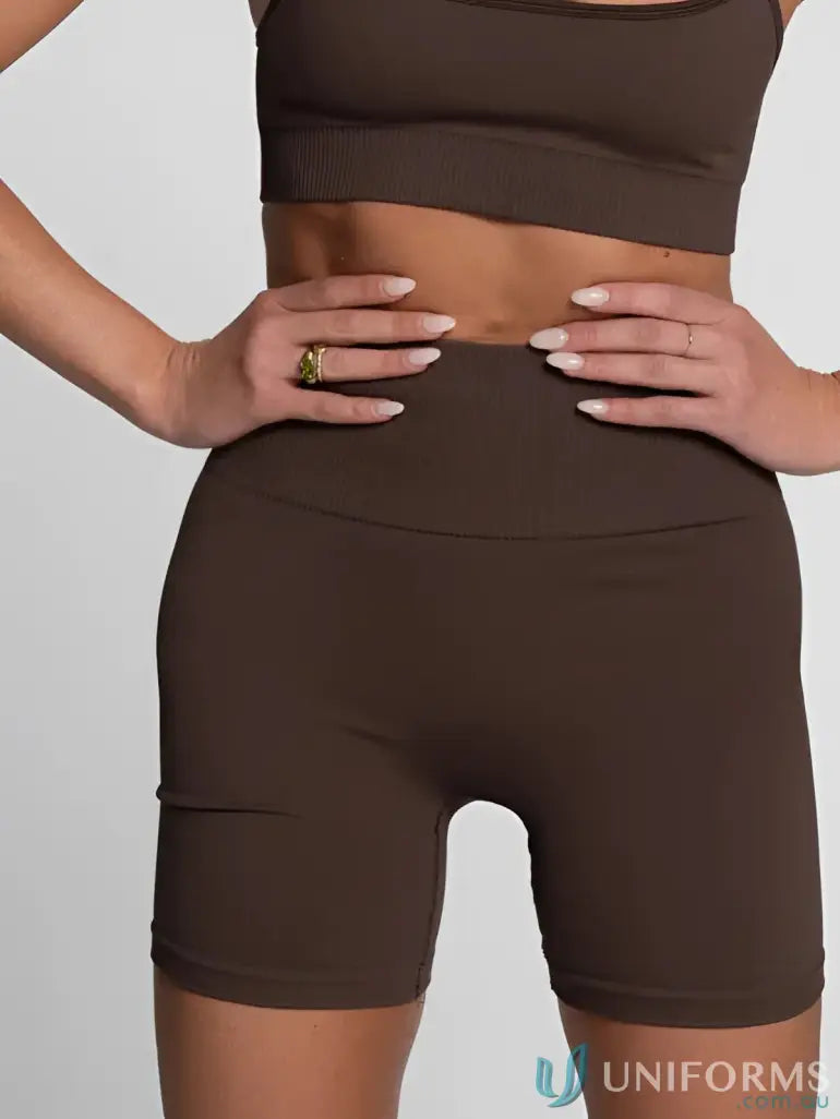 Brown high-waisted biker shorts with a fold-over waistband and pockets.