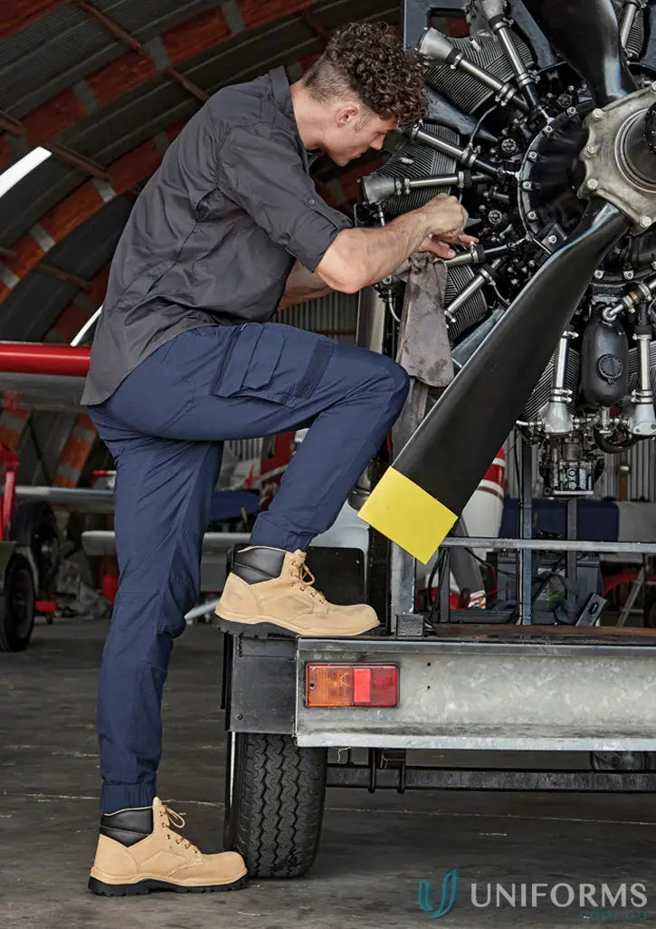 Man repairing airplane engine in Syzmic Streetworx Heritage Cuffed Pant highlighting triple-stitched crotch panel