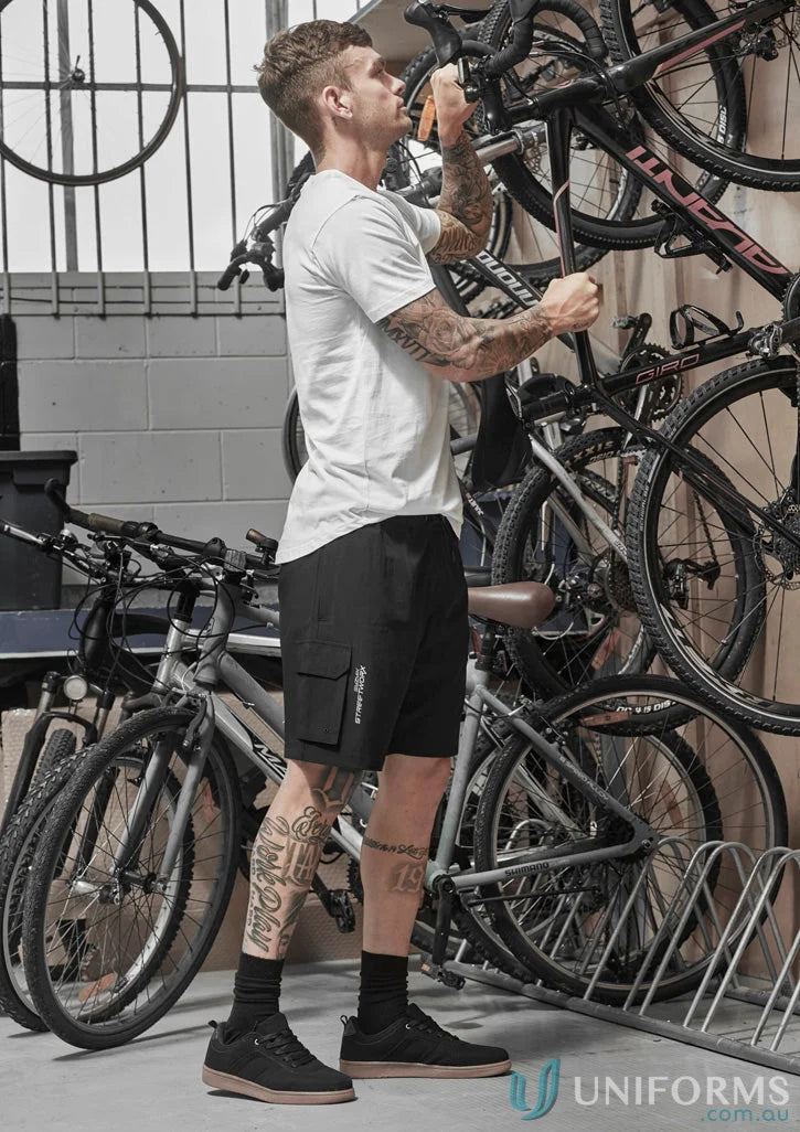 Man securing bicycle in Syzmik Men’s Streetworx stretch board shorts outdoors