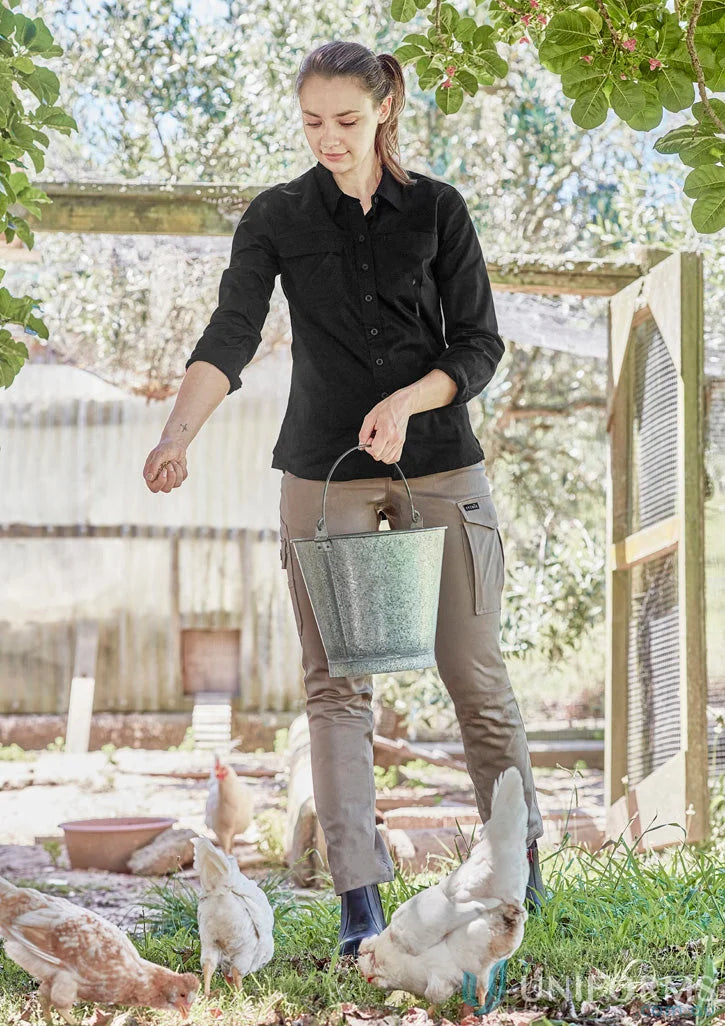 Woman feeding chickens in Syzmik Women’s Lightweight LS Tradie Shirt with feminine fit